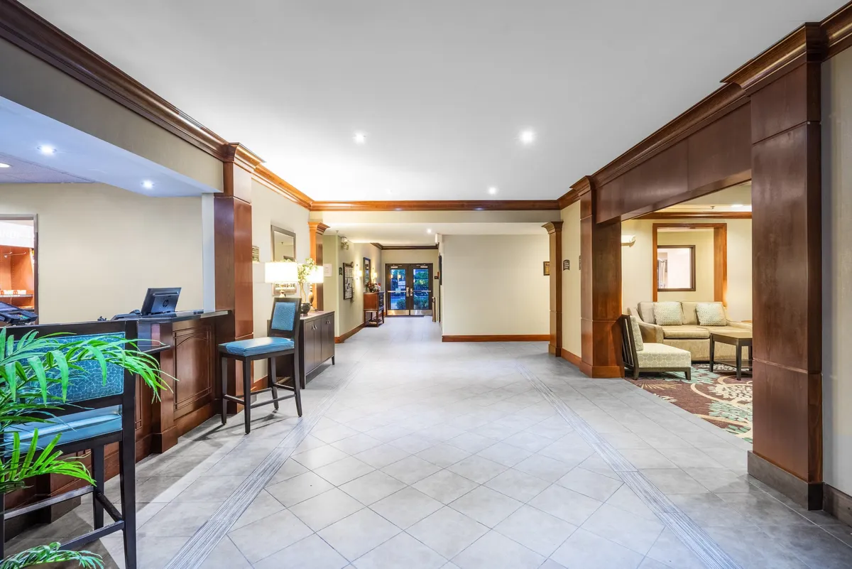 An inviting front desk area paired with a comfortable seating space near the entrance, where guests can relax, check in, or socialize. The ambiance is warm and welcoming, making it a hub for guest interactions and informal gatherings.